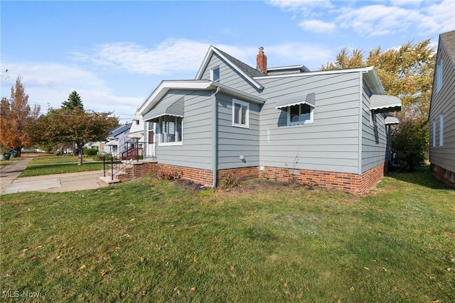 view of side of home with a lawn