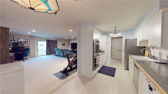 kitchen with white cabinets, pendant lighting, light carpet, and a chandelier