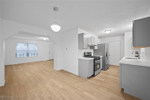 kitchen with gray cabinetry, sink, stainless steel appliances, and light hardwood / wood-style flooring