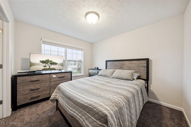 carpeted bedroom with a textured ceiling and baseboards