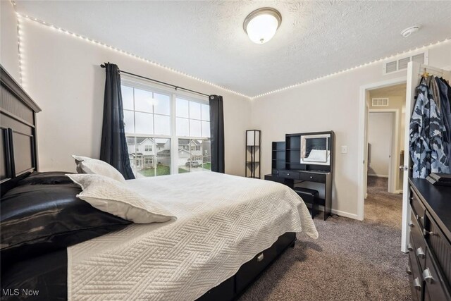 bedroom with carpet floors, baseboards, visible vents, and a textured ceiling