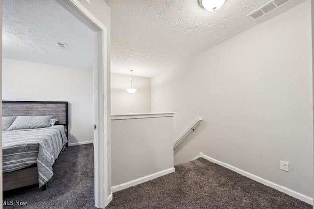 bedroom with baseboards, visible vents, and dark colored carpet