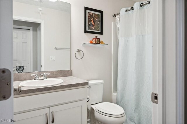 full bath featuring toilet, shower / bath combination with curtain, and vanity