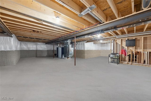 unfinished below grade area featuring gas water heater and heating unit