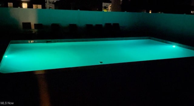 view of pool at twilight