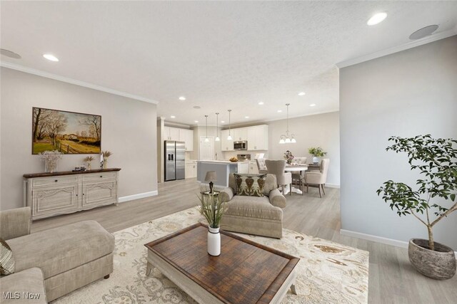 living room featuring ornamental molding, light wood-type flooring, and baseboards