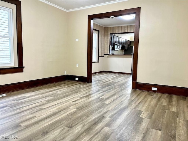 empty room featuring crown molding and light hardwood / wood-style floors