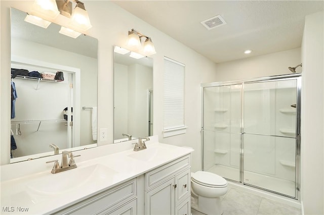 bathroom with walk in shower, vanity, tile patterned floors, and toilet