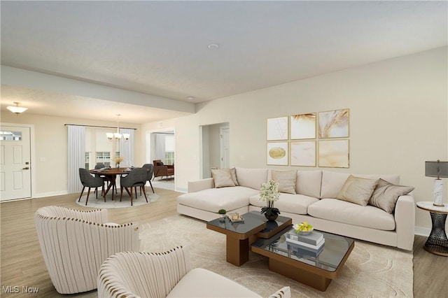 living room featuring wood-type flooring and a notable chandelier