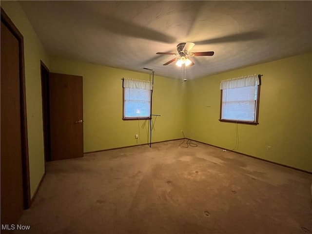 spare room with ceiling fan and light carpet