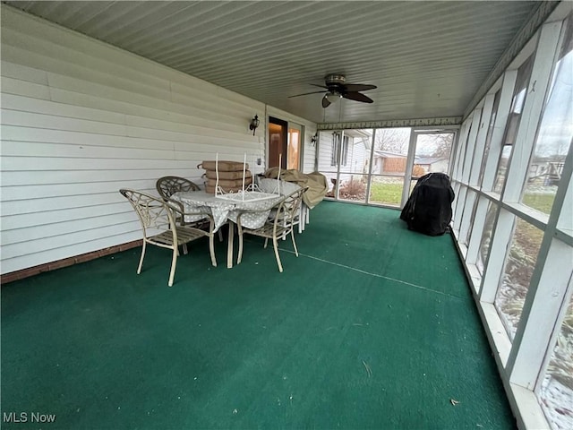 unfurnished sunroom featuring ceiling fan