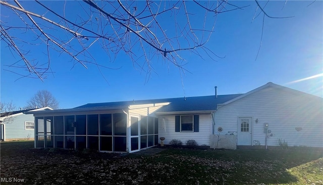 rear view of property featuring a sunroom