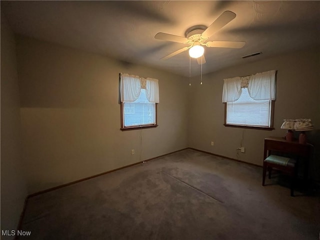 carpeted spare room featuring ceiling fan