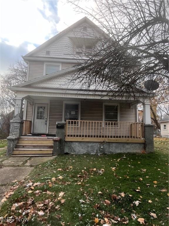 view of front of home with a porch and a front yard