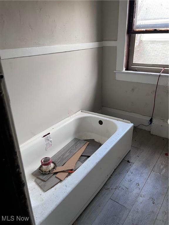 bathroom with hardwood / wood-style floors and a bathing tub