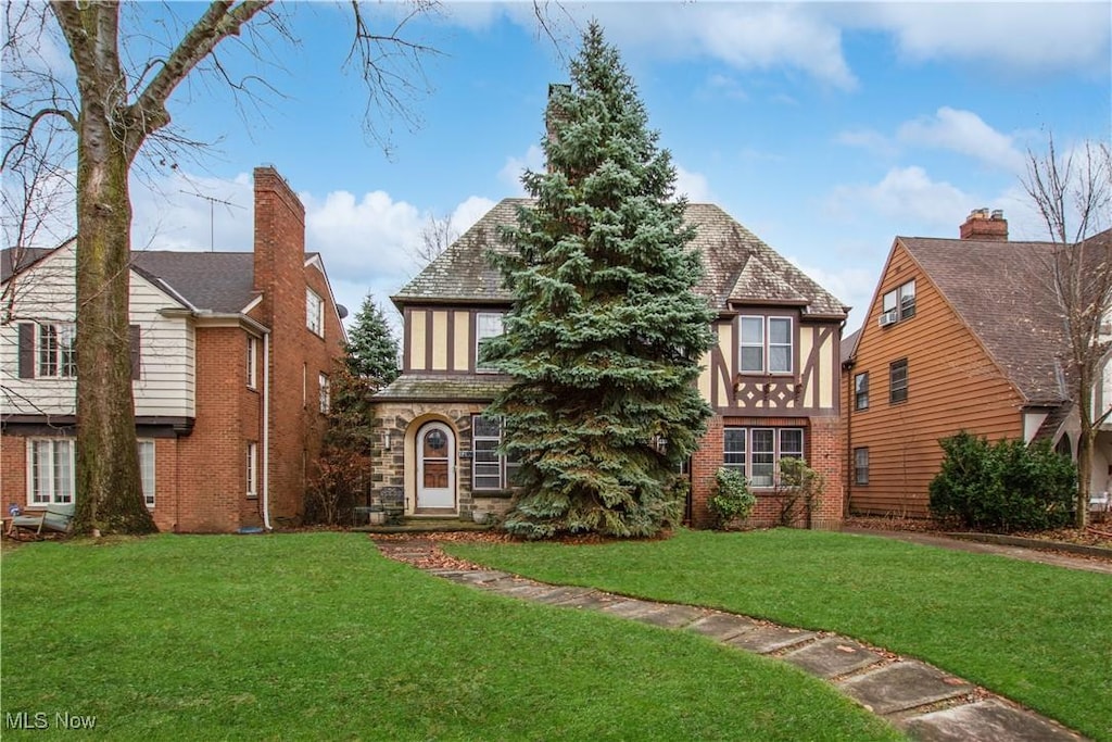 tudor-style house featuring a front yard