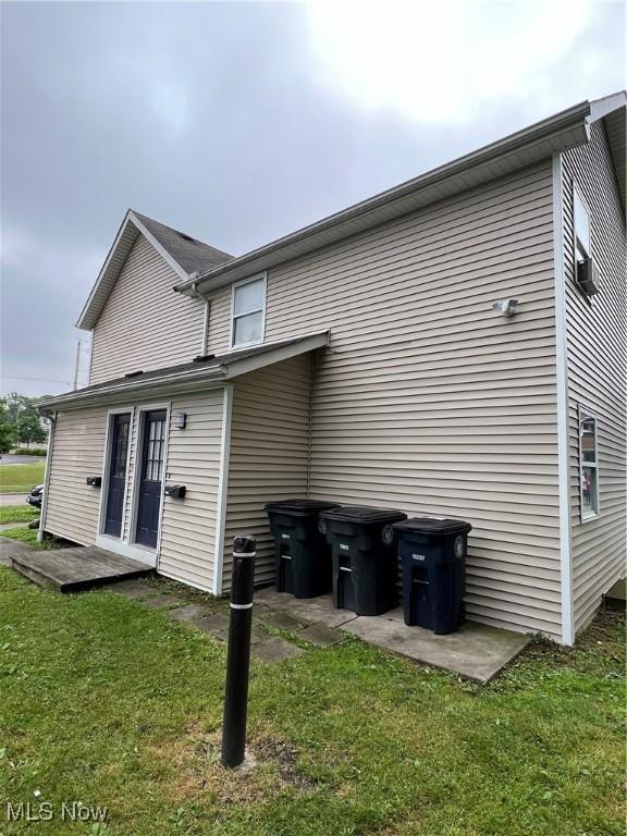 rear view of house featuring a yard