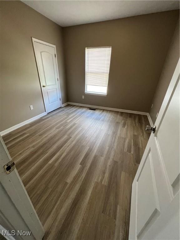 unfurnished room featuring hardwood / wood-style flooring