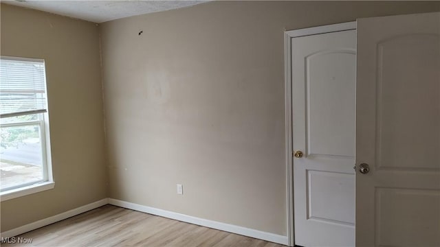 unfurnished room featuring a textured ceiling and light hardwood / wood-style flooring