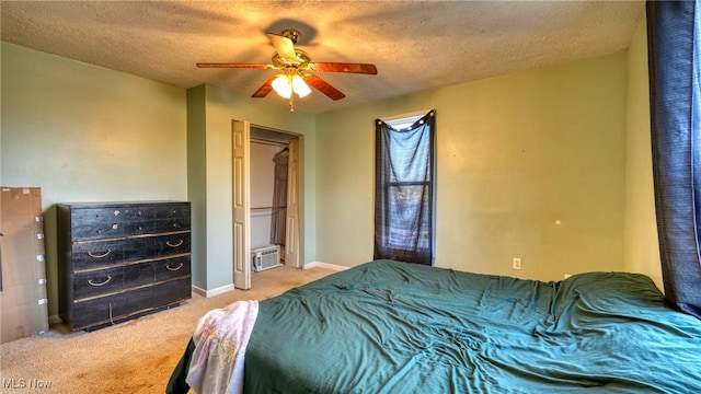 bedroom featuring ceiling fan, light carpet, and a textured ceiling