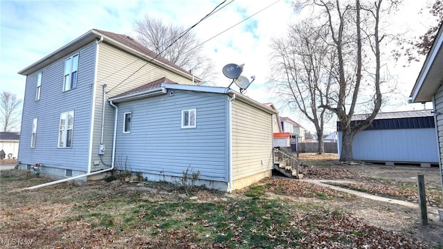 rear view of house featuring a storage unit