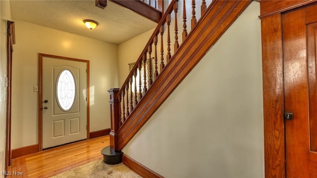 foyer featuring a textured ceiling and light hardwood / wood-style flooring