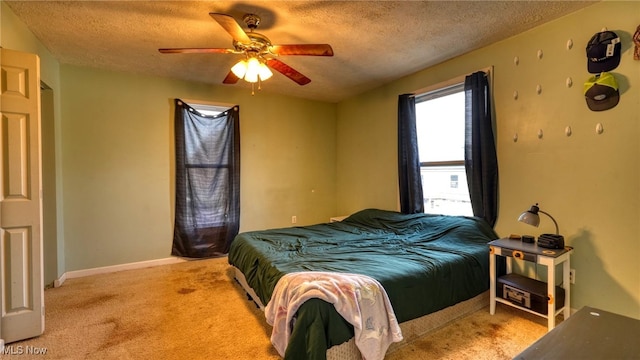 carpeted bedroom featuring ceiling fan and a textured ceiling