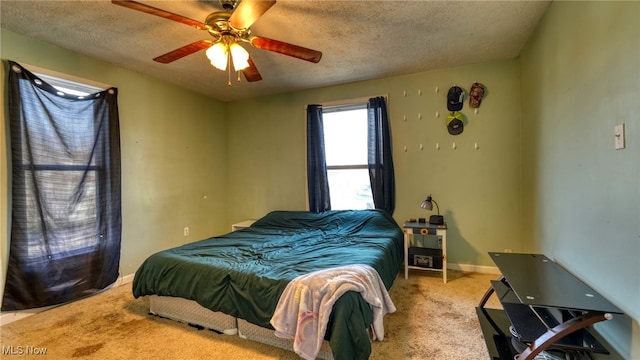 carpeted bedroom featuring ceiling fan and a textured ceiling