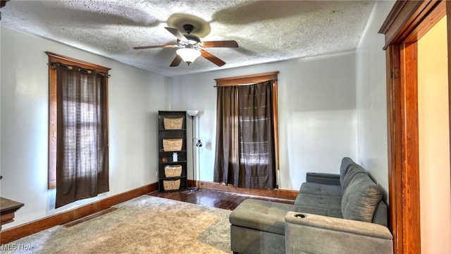 interior space with wood-type flooring, a textured ceiling, and ceiling fan