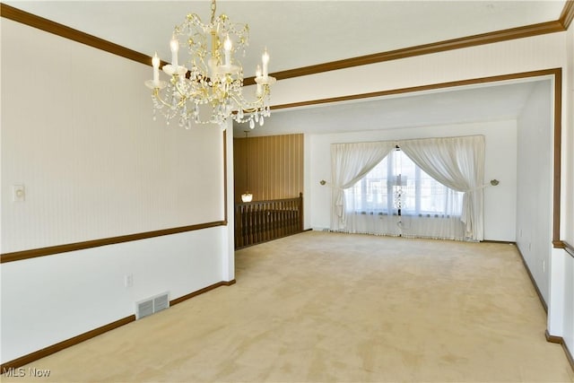 carpeted empty room with a notable chandelier and crown molding