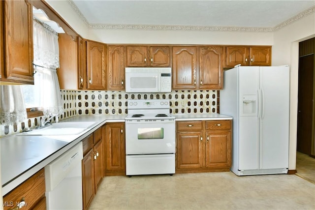 kitchen with decorative backsplash, white appliances, and sink