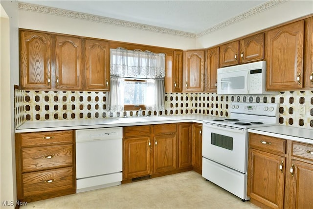 kitchen with white appliances, sink, and tasteful backsplash