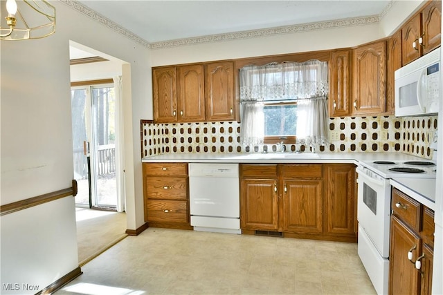 kitchen featuring white appliances, a healthy amount of sunlight, and backsplash