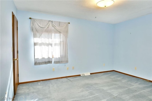 carpeted spare room with a textured ceiling