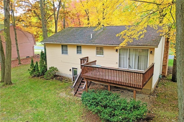 rear view of property with a wooden deck and a lawn