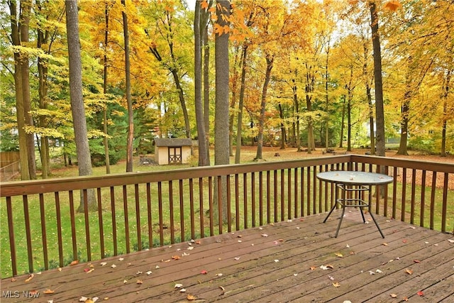 deck featuring a storage unit and a yard