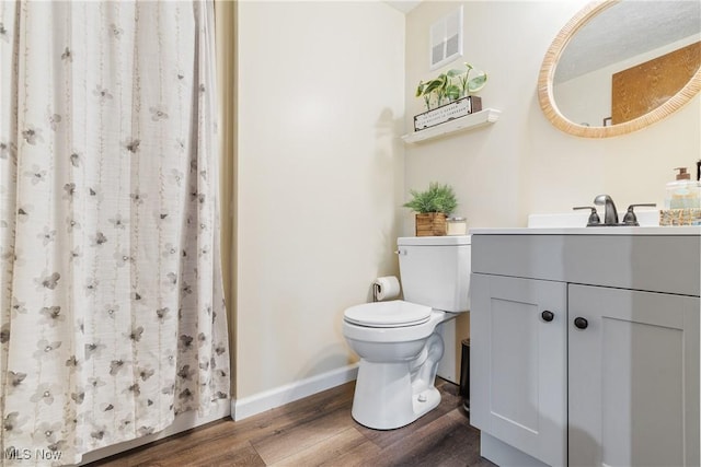 bathroom with a shower with curtain, hardwood / wood-style floors, vanity, and toilet