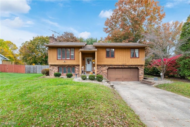 raised ranch featuring a front yard and a garage