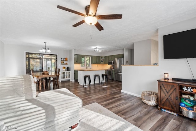 living room with a textured ceiling, ceiling fan with notable chandelier, and dark hardwood / wood-style floors