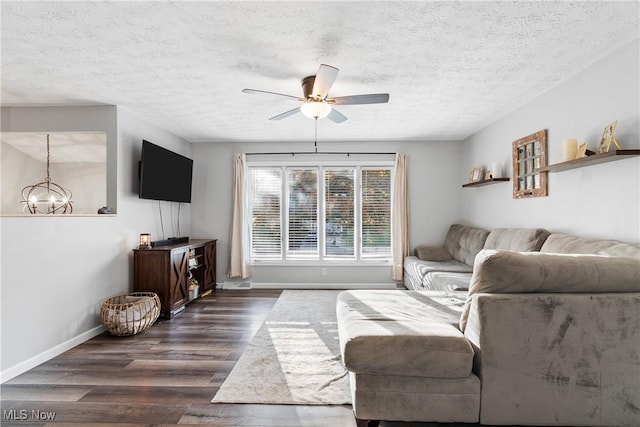 living room with ceiling fan with notable chandelier, a textured ceiling, and dark hardwood / wood-style floors