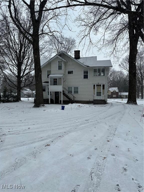 view of snow covered back of property