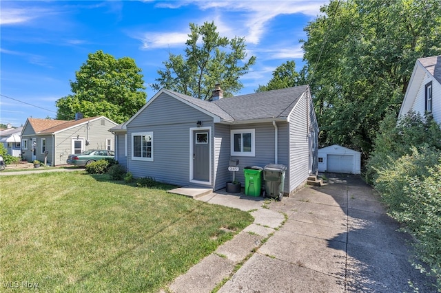 view of front facade featuring a garage, an outbuilding, and a front yard