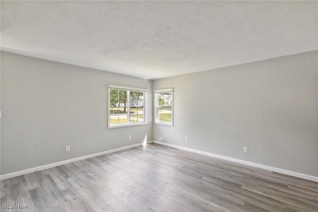 spare room featuring a textured ceiling and hardwood / wood-style flooring