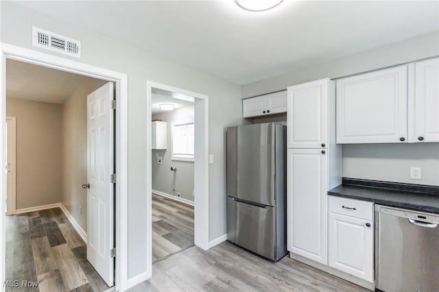 kitchen featuring white cabinets, appliances with stainless steel finishes, and light wood-type flooring