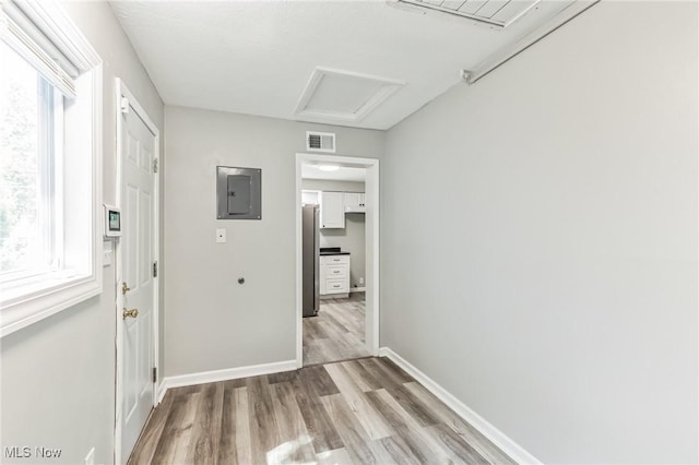 corridor featuring electric panel and light hardwood / wood-style flooring