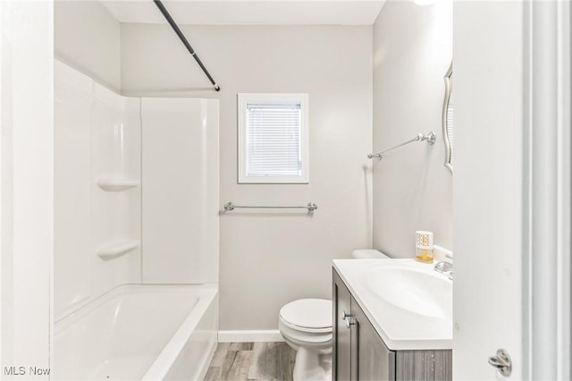 full bathroom featuring washtub / shower combination, hardwood / wood-style floors, vanity, and toilet