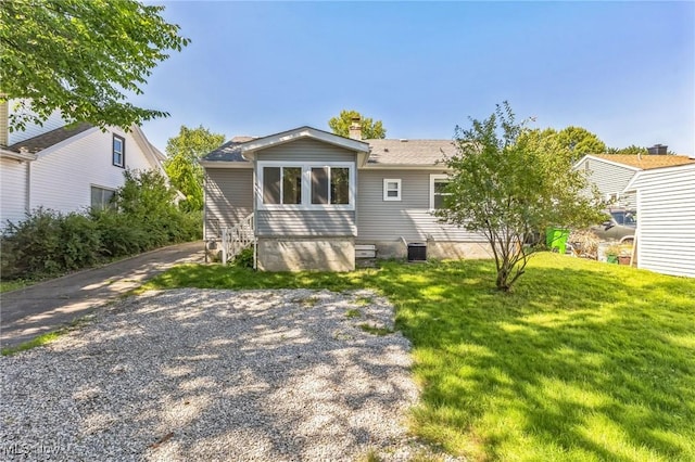 rear view of house with a lawn and central AC