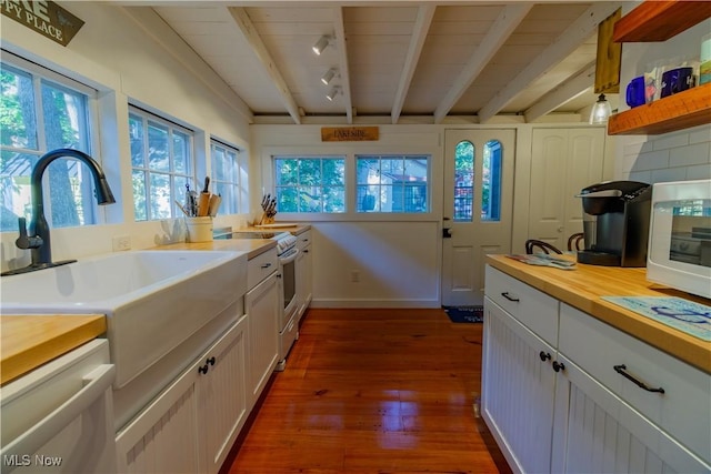 kitchen featuring dark wood-type flooring, sink, beamed ceiling, dishwasher, and white cabinets