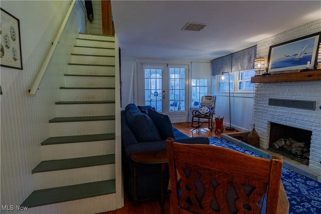 living room featuring hardwood / wood-style floors, a fireplace, and french doors