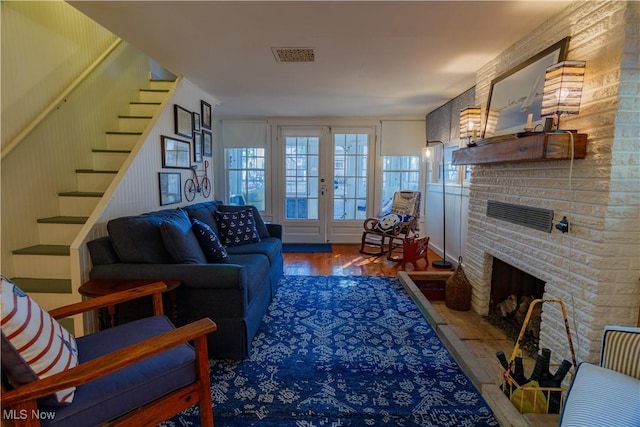 living room with a fireplace, hardwood / wood-style floors, and french doors